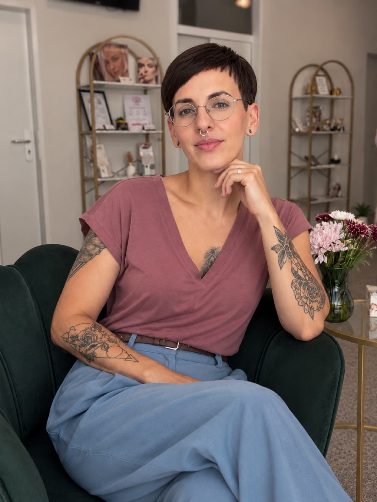 Laura Maskus in ihrem Institut, im grünen Sessel vor goldenen Regalen